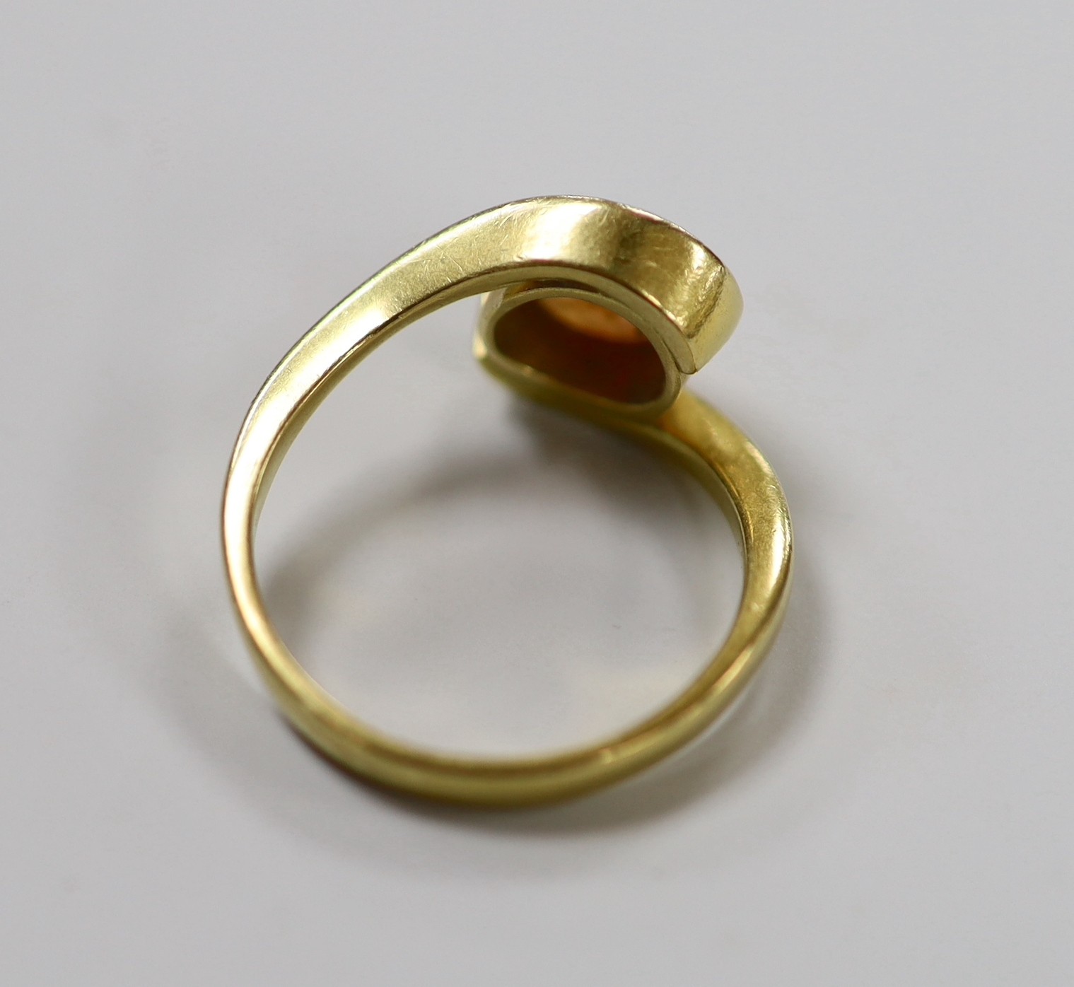 An 18ct and single stone oval white opal set ring, with crossover shoulders, size Q, gross weight 5.6 grams.